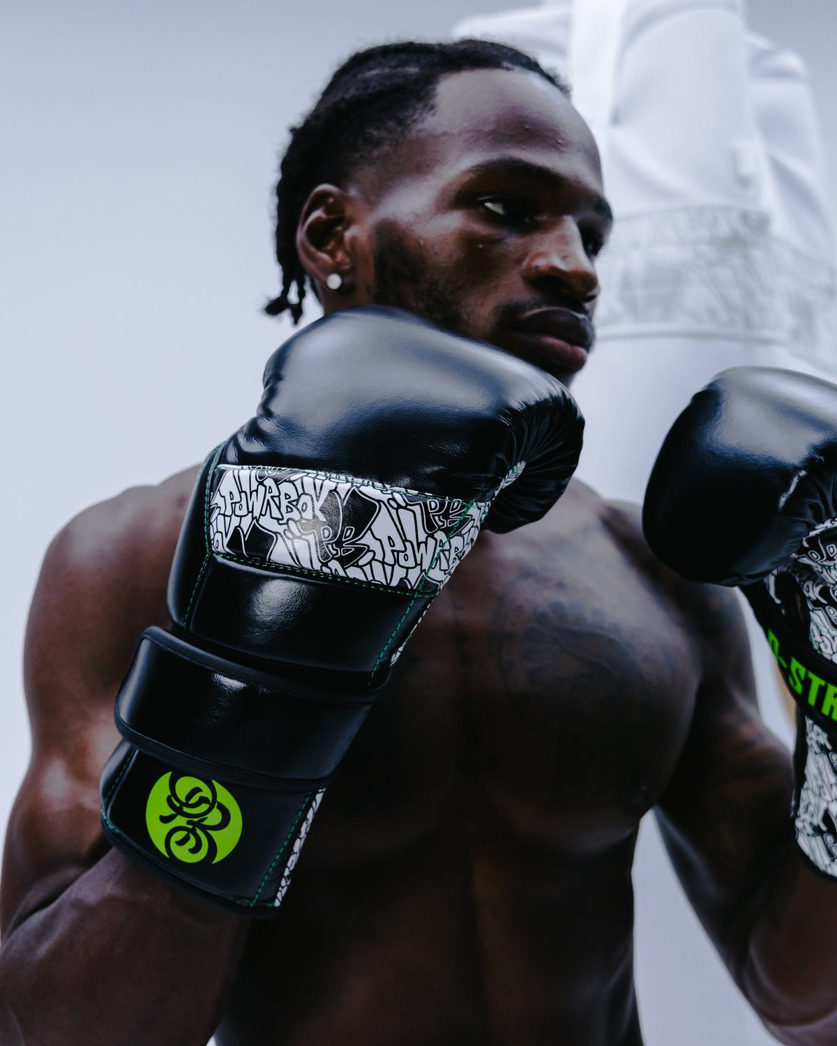 Boxer wearing Powrbox D-Strap Double Velcro Gloves in Toxoid gloss black, green and white